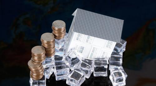 House on pile of ice next to stack of coins