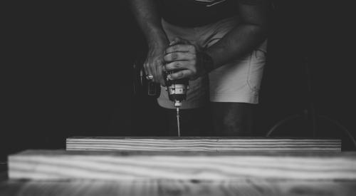 Person drilling hole in plywood