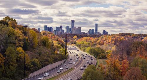 View of tree-lined highway into city