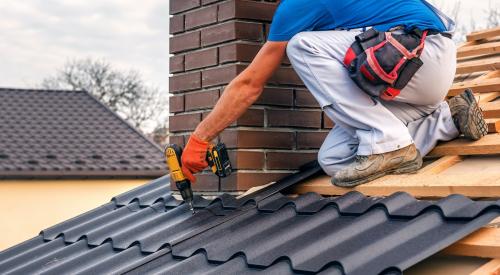 Worker fastening fire-resistant metal roof