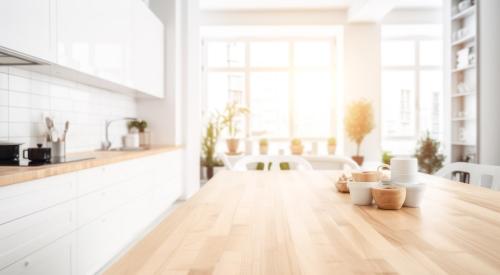 View of modern kitchen looking across countertop toward windows