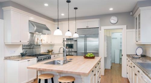 Modern white kitchen with central island and stainless steel appliances