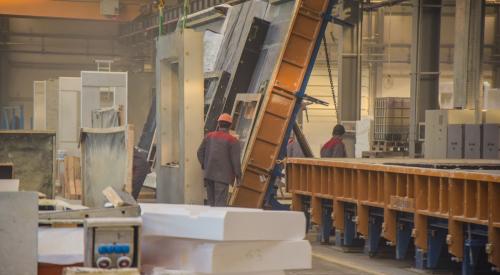 Builders working on modular home inside of factory