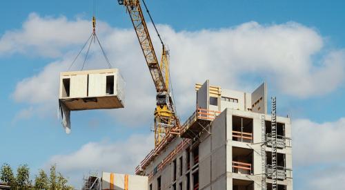 Crane lifting part of modular home into place