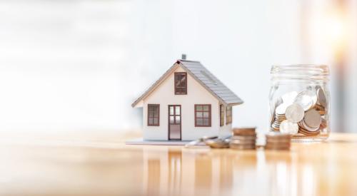 White house model next to stack of coins and a jar of money