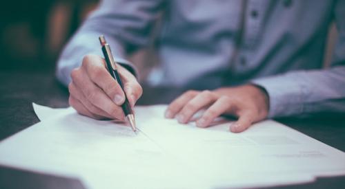 Hands_signing_contract_on_desk