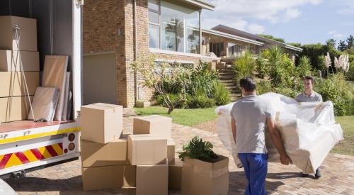 Movers carrying couch into new home