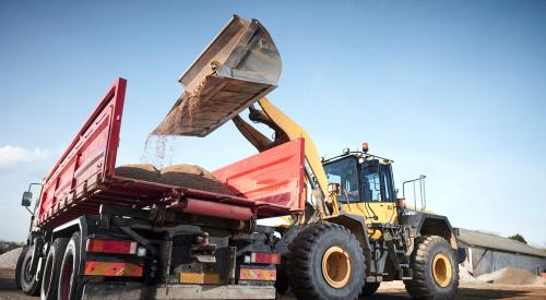 Bucket loader loading dirt into a dump truck on a construction jobsite