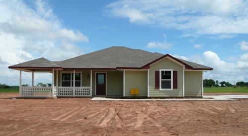 New house with for-sale sign on bulldozed lot