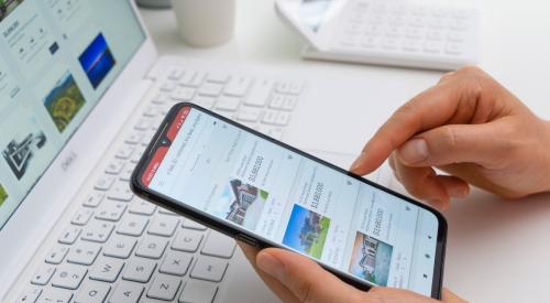 Person scrolling through home listings on smartphone