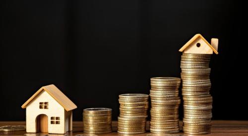 Small house models next to stacks of coins growing in size