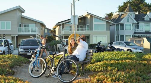 Two people sitting on bench near homes