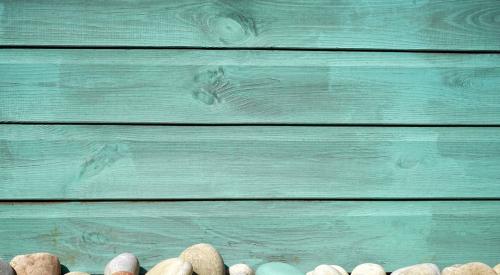 Blue siding with stones and grass