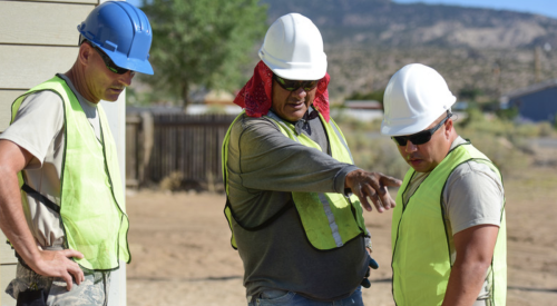 Foreman pointing out a mistake on a construction site to two other crew members