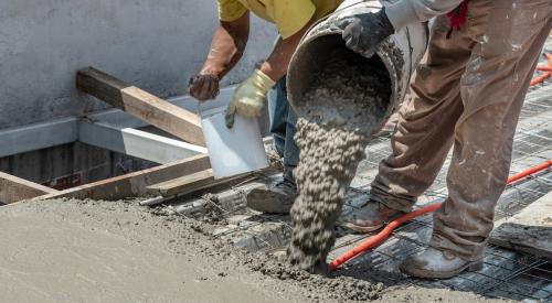 Builders pouring concrete on jobsite