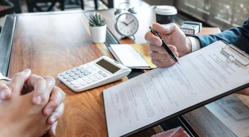 Homebuyer preparing to sign purchase agreement in realtor office