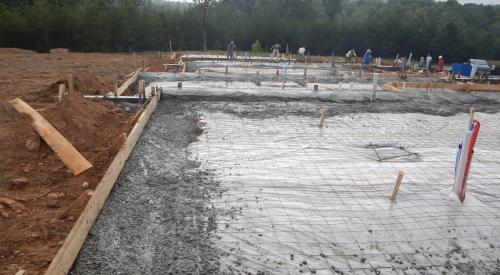 Work in progress on a slab-on-grade concrete foundation with rebar and poured concrete 