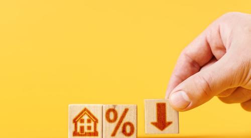 House, percentage, and downward arrow on small wooden blocks against yellow background