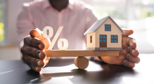 Man holding balanced scale of percentage point and white house