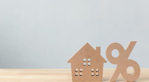 Wood house next to percentage sign to represent home mortgage rates