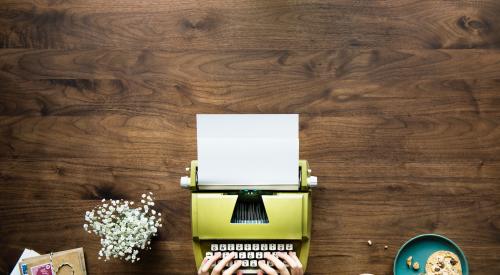 Tabletop with typewriter, food, and notebook