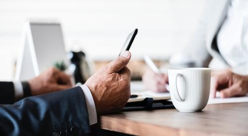 Businessman at table looking at smartphone