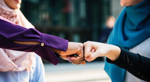 Women fist-bumping