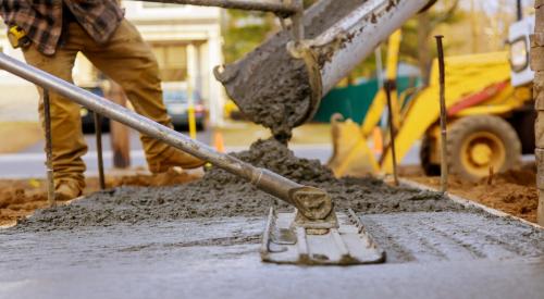 Construction workers pouring and smoothing concrete