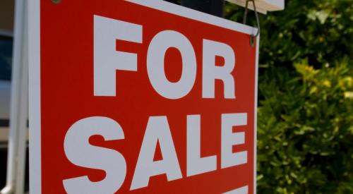 Red and white for sale sign in residential yard