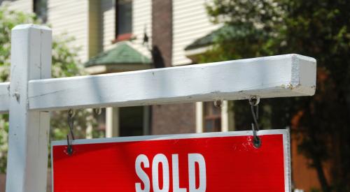 Red home sold sign in yard