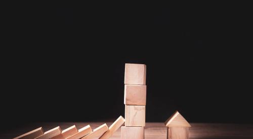 Wooden blocks falling onto small house