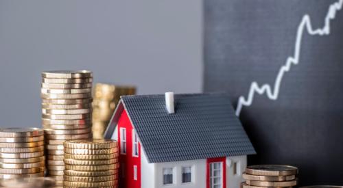 Rising line graph covered by small red house model next to stacks of coins