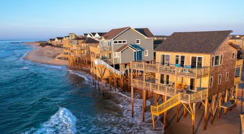 Coastal homes on stilts with tide washing underneath