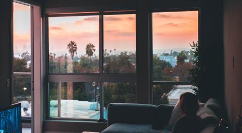 Woman sitting in living room during sunset