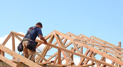 Roofer working on top of new residential structure