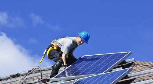 Man-on-roof-installing-solar-panels