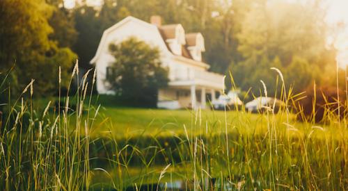 view across front lawn of rural home with nearby stream