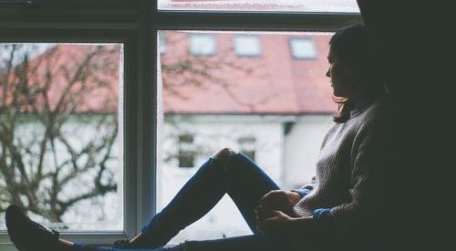 Sad woman looking out window