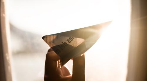 Person with check as paper airplane on an airplane