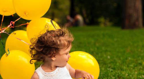 Little girl with yellow balloons