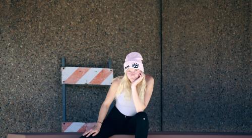 Millennial outside sitting on ledge