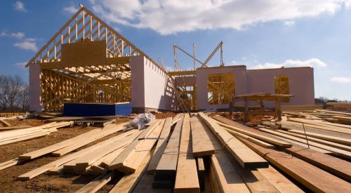 New single-family house and stacks of lumber ready for framing