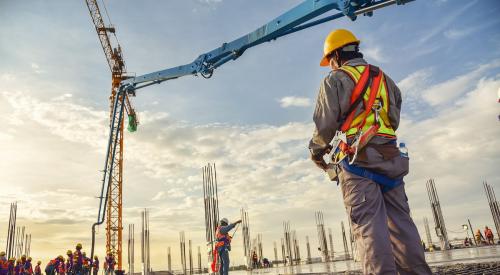 Construction workers on jobsite at sunset