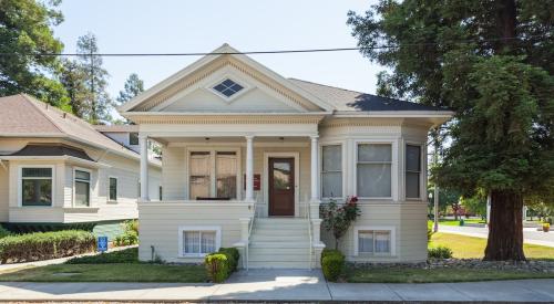 Small white entry level home seen from street curb