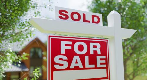 Red and white home for sale sign with "sold" posted on top