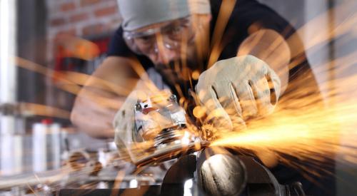 Sparks flying from man cutting metal pipe