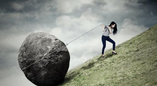 Woman pulling boulder uphill