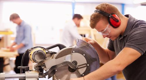 Construction student using chop saw