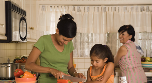 Three generations of women chopping vegetables together in the multigenerational kitchen