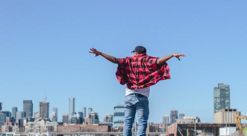 Man standing on dock with arms outstretched